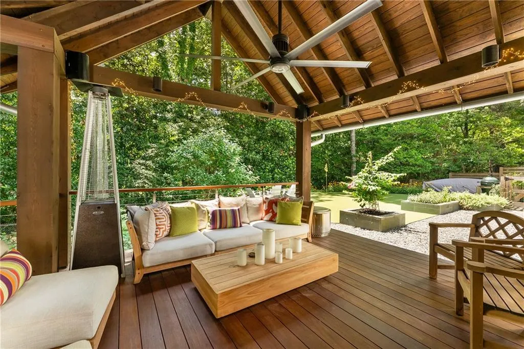 Deck featuring an outdoor hangout area, ceiling fan, and view of scattered trees