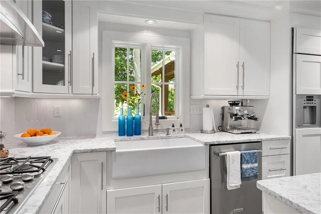 Kitchen featuring white cabinetry, appliances with stainless steel finishes, and exhaust hood