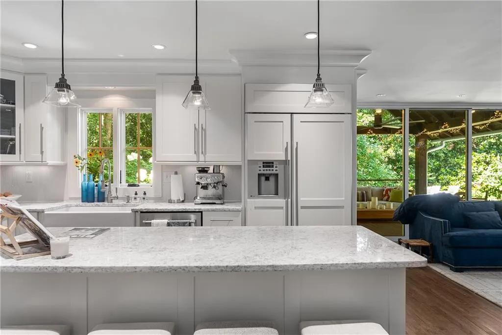 Kitchen featuring Carrera countertops, white cabinetry, backsplash, paneled refrigerator, and recessed lighting