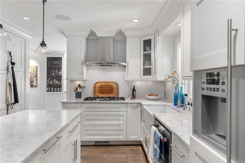 Kitchen featuring Carrera countertops, white cabinetry, dark wood-style floors, fridge, and recessed lighting