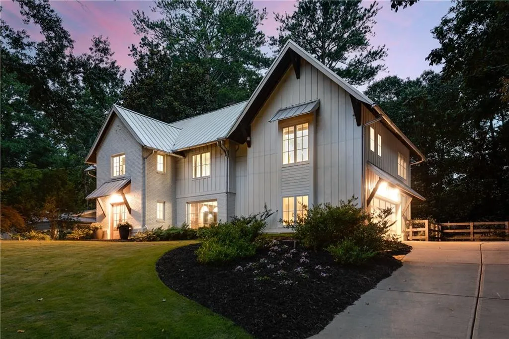 Modern farmhouse with board and batten siding, driveway, an attached garage, a Zoysia grass front yard.