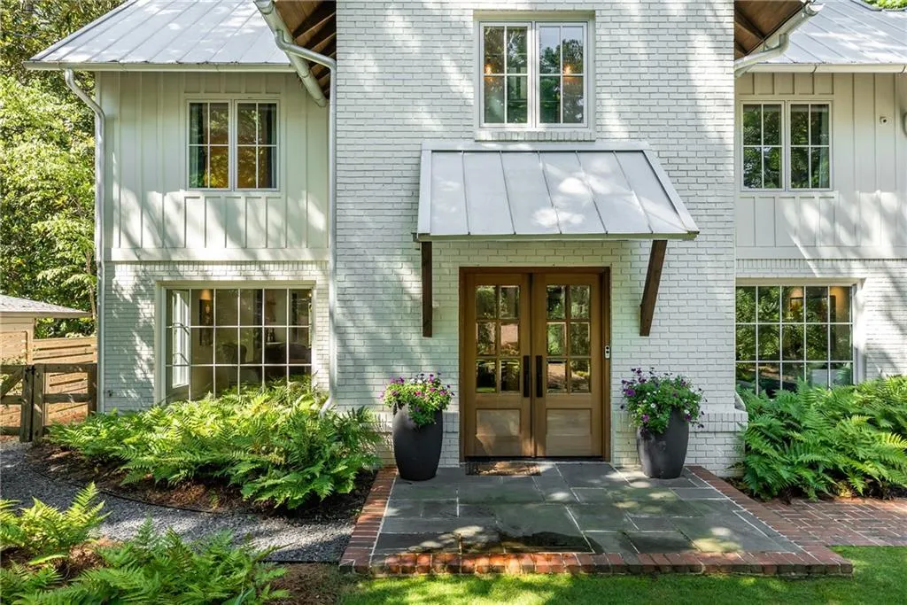 Property entrance with board and batten siding, french doors, and brick siding