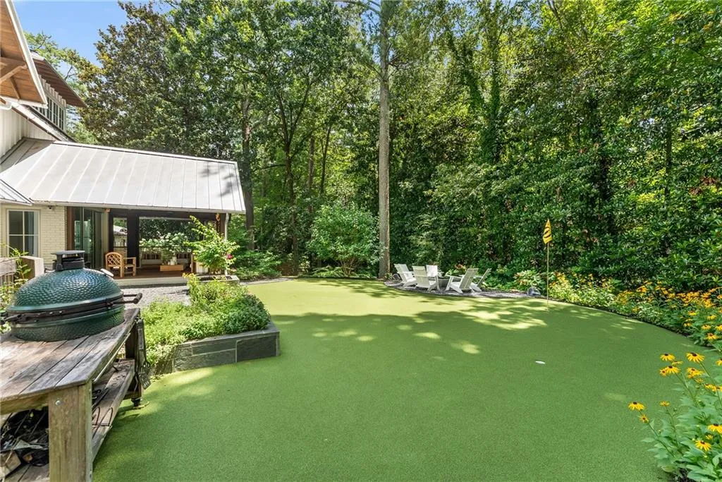 View of yard with a patio, a putting green, and view of scattered mature landscaping
