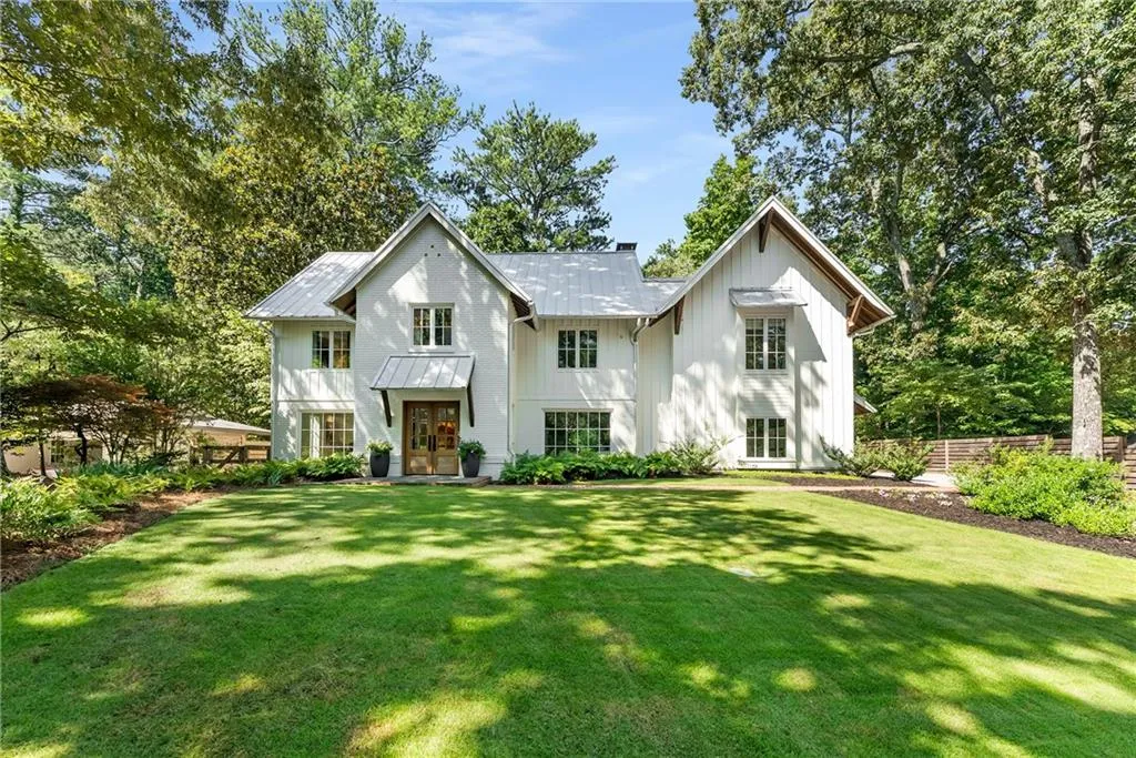 Modern inspired farmhouse with board and batten siding, a metal roof, and french doors