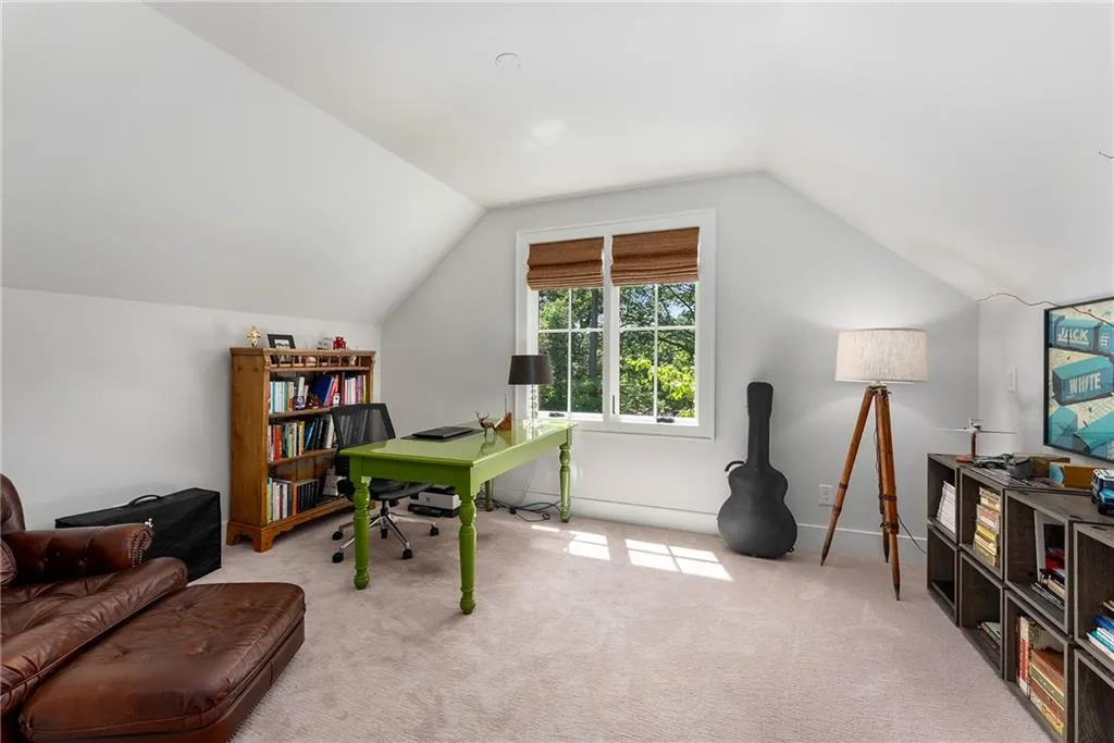 Office area featuring lofted ceiling and carpet