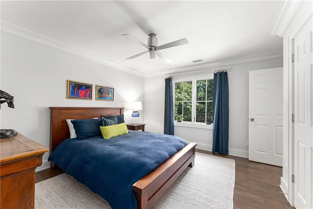 Bedroom featuring crown molding, wood finished floors, and a ceiling fan