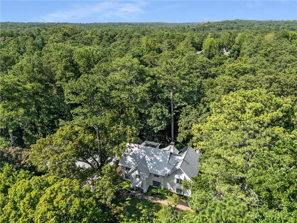 Aerial view of property and surrounding area featuring a heavily wooded area