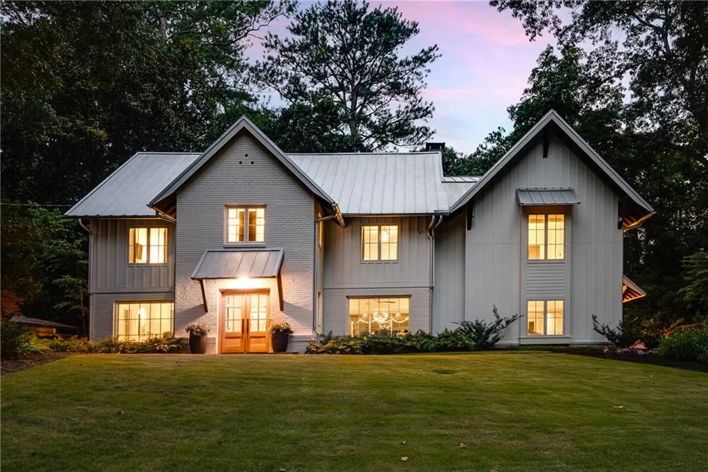 Front of house at dusk featuring a yard, board and batten siding, a metal roof, and a standing seam roof
