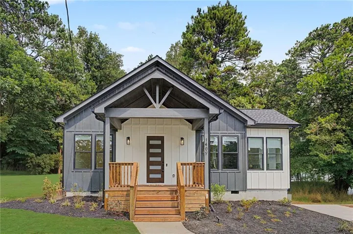 Modern farmhouse exterior with gray vertical siding and white board and batten accents