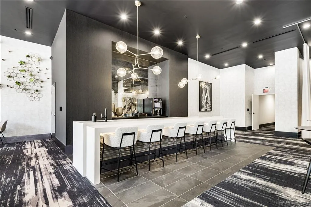 Bar featuring dark tile patterned floors, hanging light fixtures, recessed lighting, freestanding refrigerator, and a towering ceiling