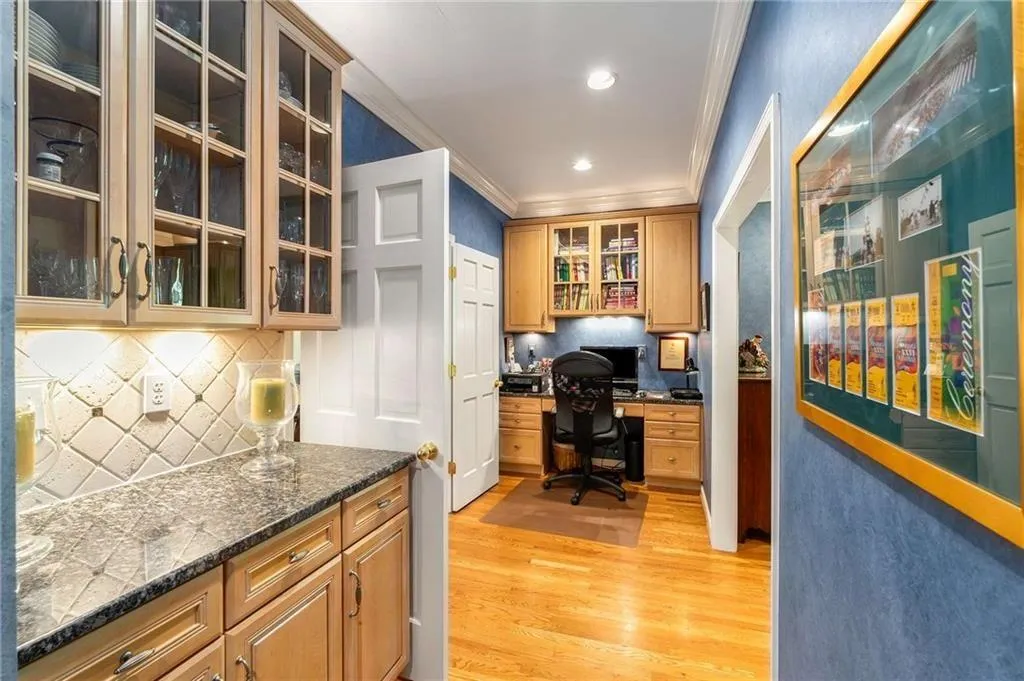 Butlers pantry and Home office with built in desk, crown molding, light wood-type flooring, and recessed lighting