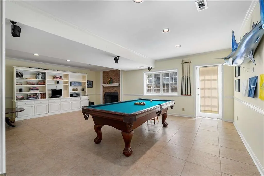 Recreation room on terrace level featuring ornamental molding, pool table, recessed lighting, a brick gas fireplace, and light tile patterned floors