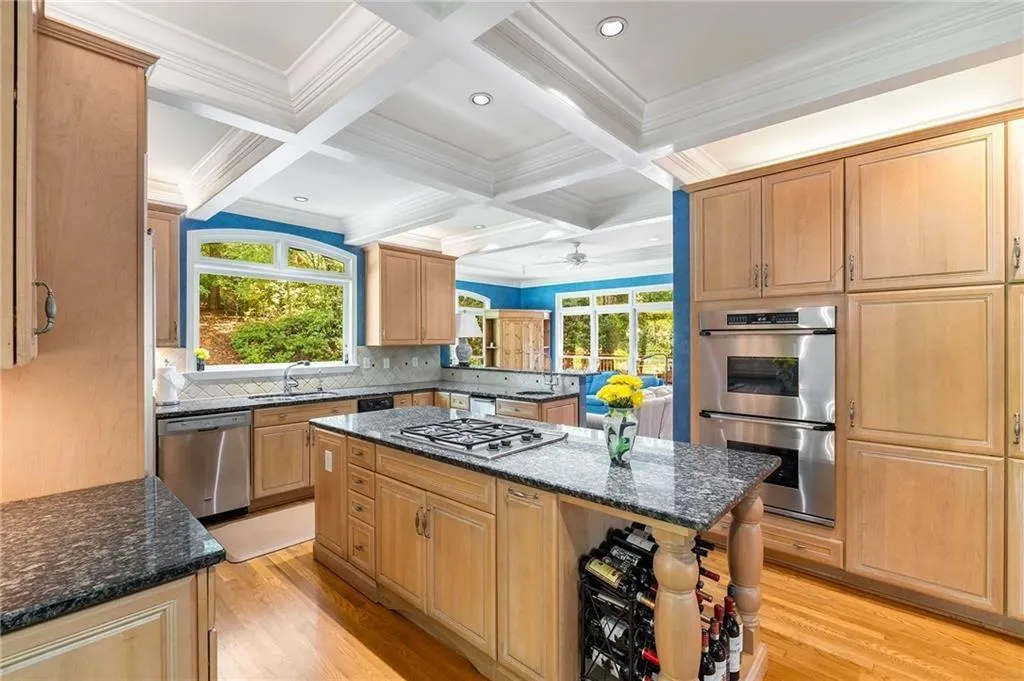 Kitchen with coffered ceiling, beamed ceiling, ornamental molding, stainless steel appliances, Double ovens and a kitchen island with gas cooktop