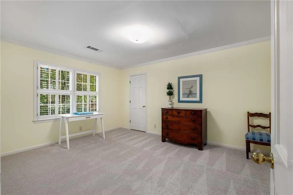 Large secondary bedroom with new carpet flooring and ornamental molding