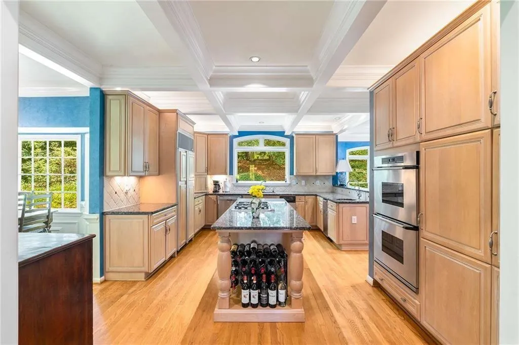 Kitchen featuring coffered ceiling, ornamental molding, beamed ceiling, backsplash, and stainless steel appliances