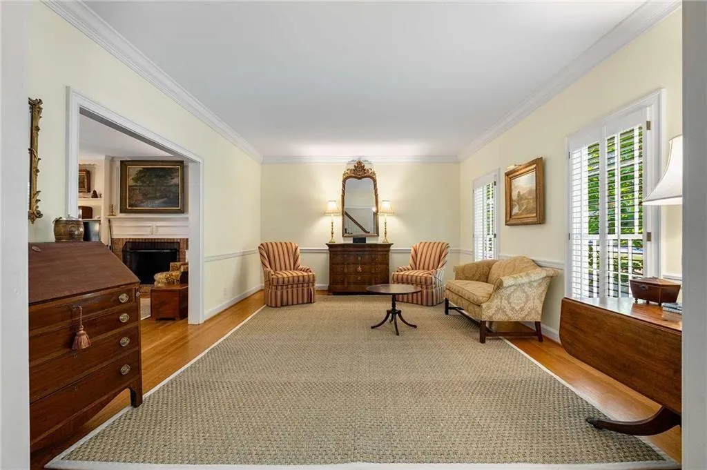 Formal living room with lots of natural light, elegant molding, wainscoting, finished hardwood floors.