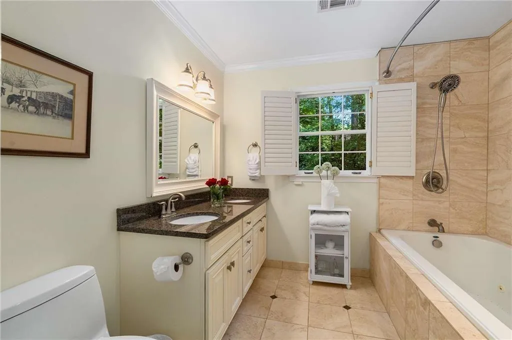 Bathroom featuring vanity, ornamental molding, tiled shower / bath, and tile patterned flooring