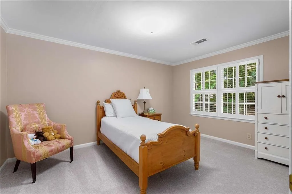 Bedroom featuring light carpet and ornamental molding