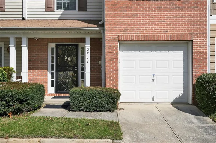 Brick facade with a single-car garage and concrete driveway