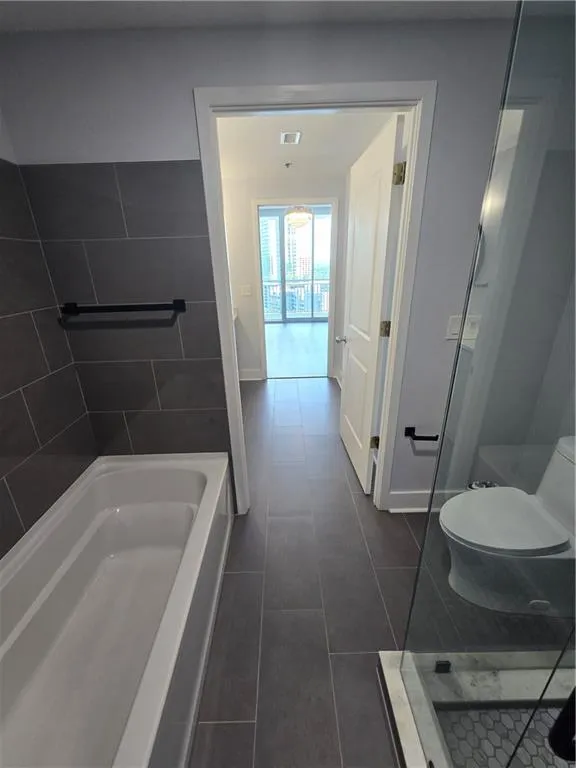 Full bath featuring tile patterned floors and a shower