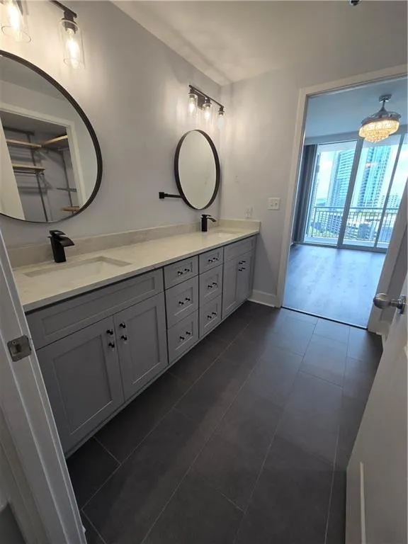 Full bath featuring double vanity and tile patterned flooring