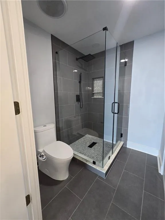 Full bathroom featuring a stall shower and tile patterned flooring