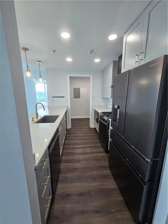 Kitchen featuring fridge, range, dishwasher, dark wood finished floors, and recessed lighting