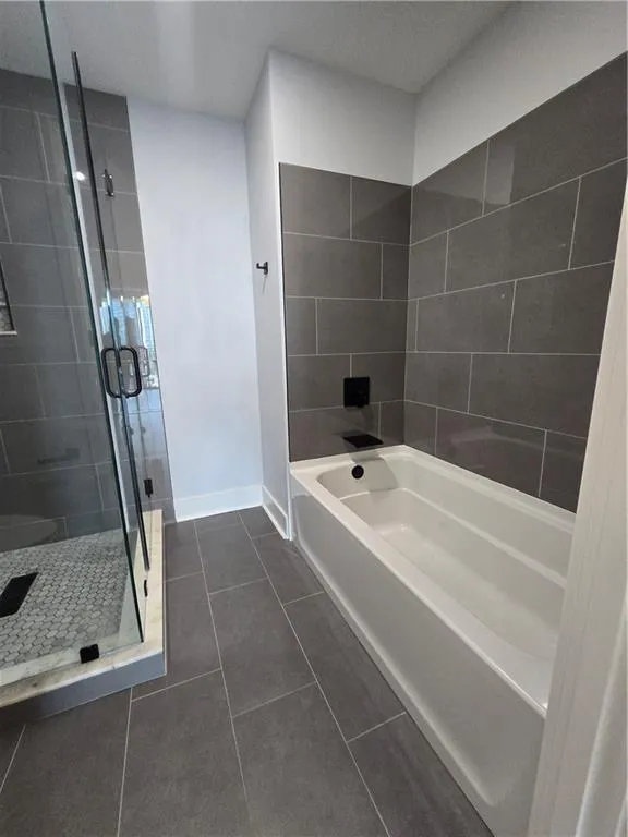 Full bath with a garden tub, a stall shower, and tile patterned flooring
