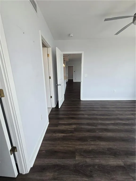 Spare room featuring a ceiling fan, wood finished floors, and a smoke detector