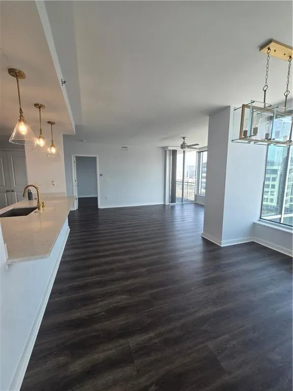 Unfurnished dining area featuring dark wood-type flooring and ceiling fan