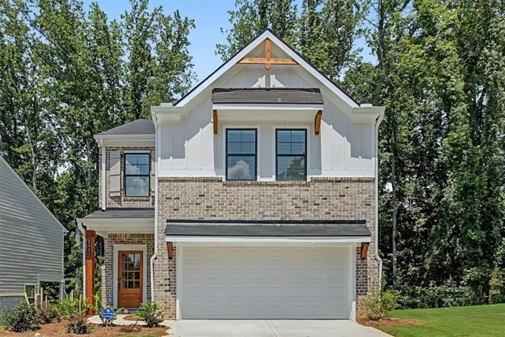 Brick and siding exterior with a prominent gable, wood-look accents, a two-car garage, and a transom-style entry door