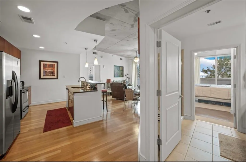 Kitchen with appliances with stainless steel finishes, pendant lighting, a kitchen breakfast bar, recessed lighting, and arched walkways