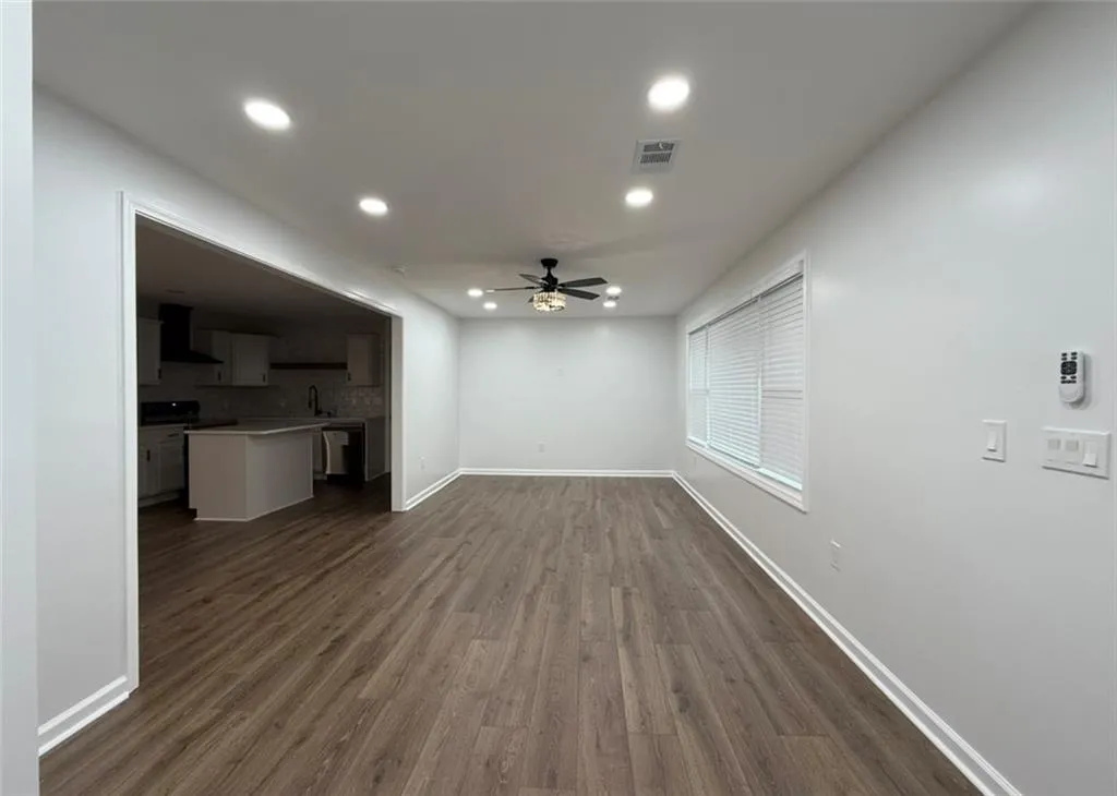 Unfurnished living room with dark wood-style flooring, recessed lighting, and ceiling fan