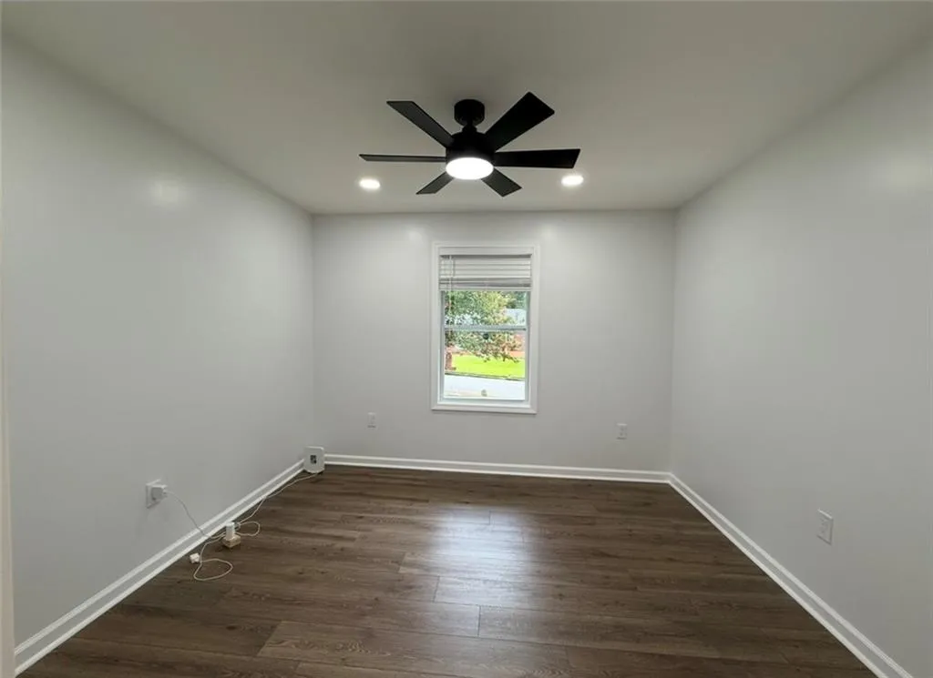 Empty room featuring dark wood finished floors, recessed lighting, and a ceiling fan