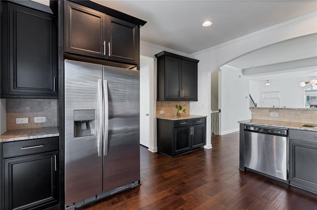 Kitchen featuring granite countertops, stone tile backsplash, and stainless steel appliances Kitchen featuring granite countertops, stone tile backsplash, and stainless steel appliances