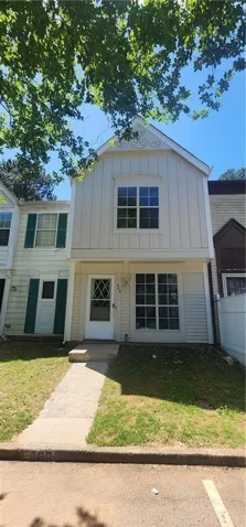White exterior siding with a prominent peaked gable, featuring decorative trim