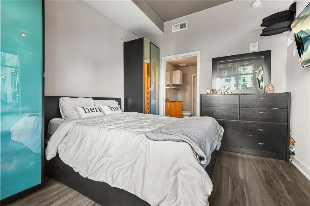 Bedroom with ensuite bathroom and dark wood-style flooring Bedroom with ensuite bathroom and dark wood-style flooring