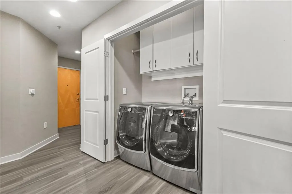 Laundry room featuring light wood-style flooring, cabinet space, recessed lighting, and washer and dryer Laundry room featuring light wood-style flooring, cabinet space, recessed lighting, and washer and dryer
