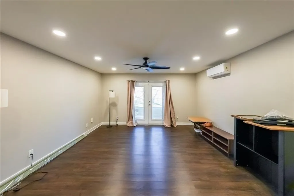 Unfurnished living room featuring ceiling fan, recessed lighting, french doors, dark wood-style floors, and a wall mounted AC