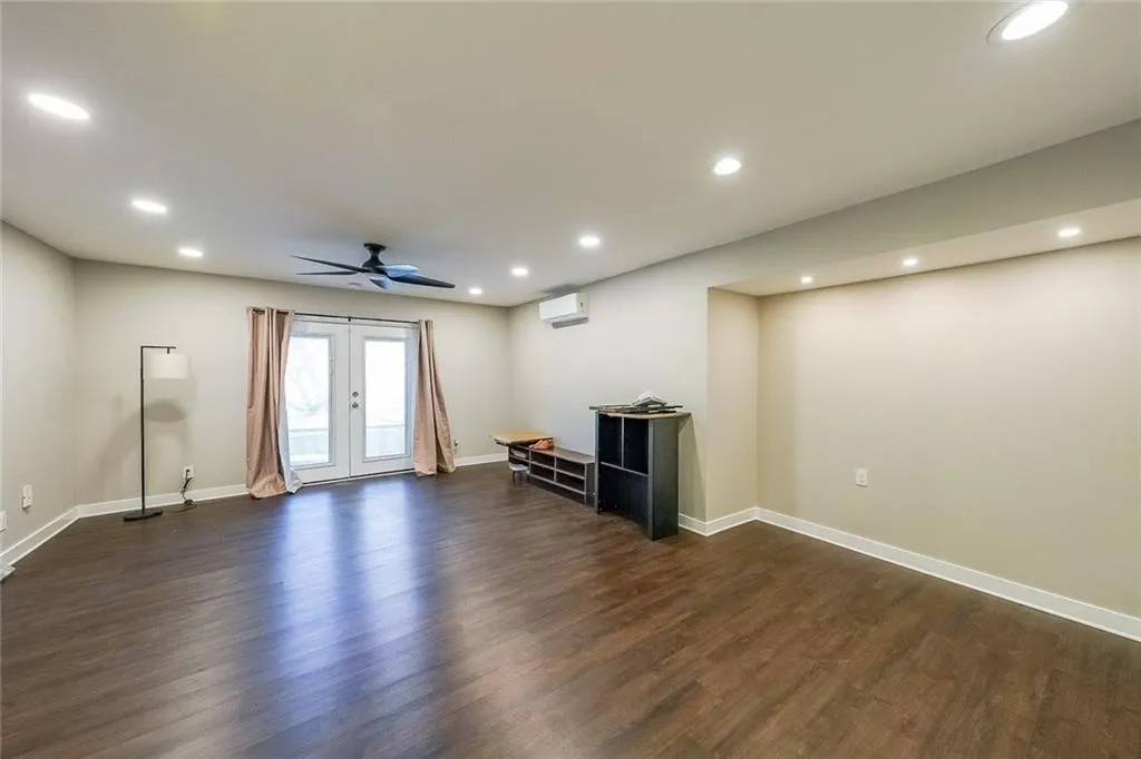 Unfurnished living room featuring baseboards, recessed lighting, ceiling fan, dark wood-type flooring, and a wall mounted air conditioner