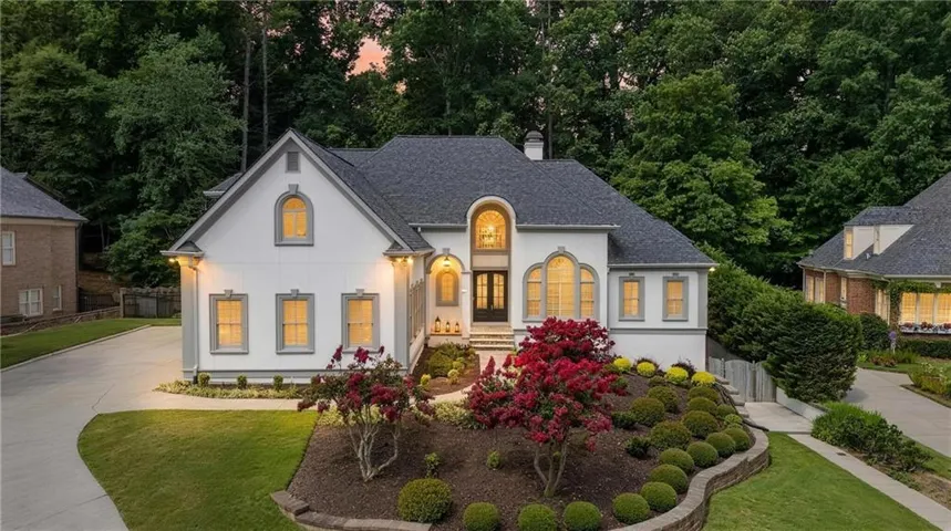 Classic architecture, a welcoming covered entry, and mature landscaping create a beautiful first impression at this extensively renovated Wellington Lake home.