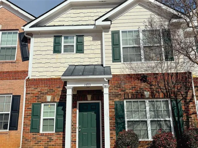 View of front of property with brick siding and a standing seam roof