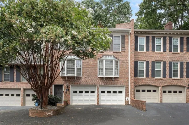 Brick townhome exterior featuring a prominent bay window with white trim