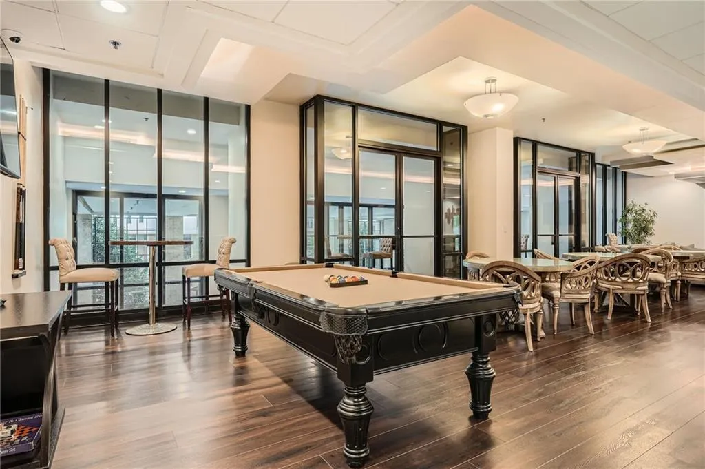 Recreation room with plenty of natural light, expansive windows, billiards, and dark wood-style flooring