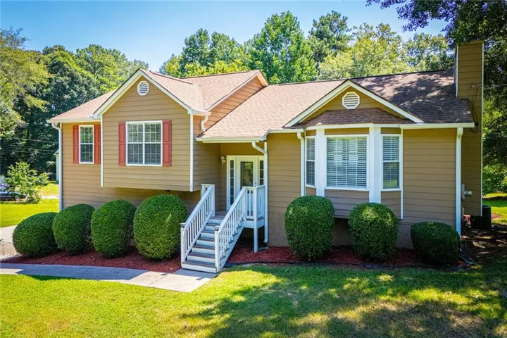 Contemporary exterior with a multi-level design, featuring a prominent front entrance staircase, bay window, and gabled rooflines