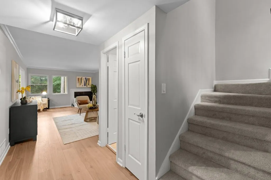 Stairs with hardwood / wood-style flooring and ornamental molding