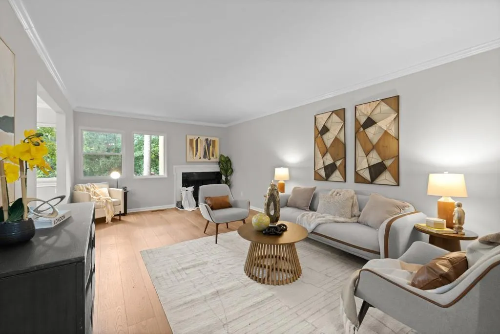 Living room with ornamental molding and light hardwood / wood-style floors