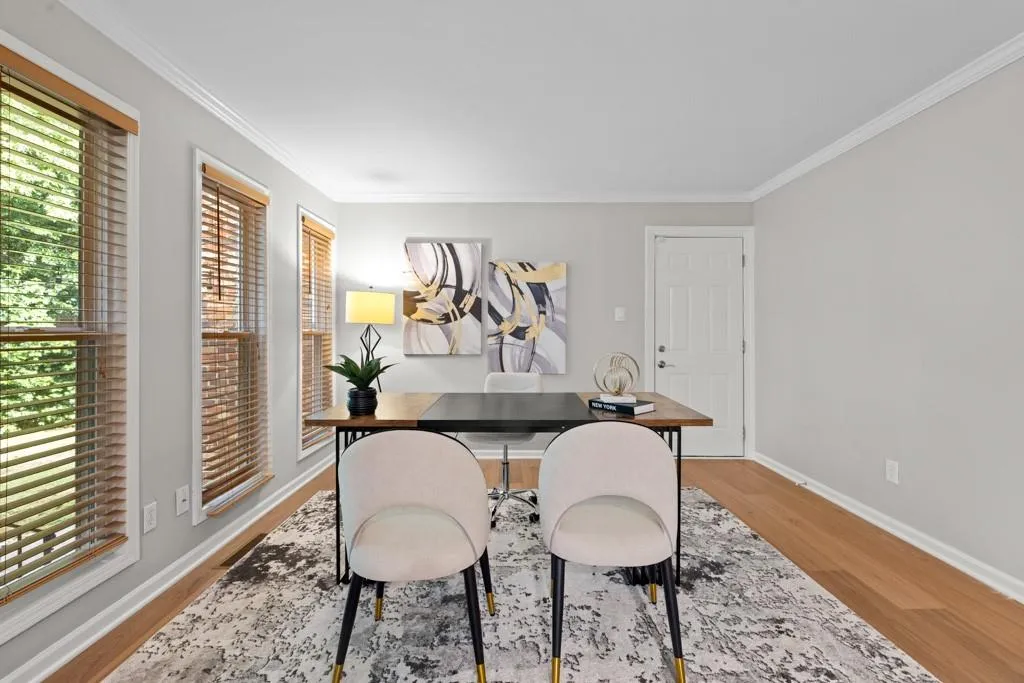 Home office featuring a wealth of natural light, hardwood / wood-style flooring, and crown molding