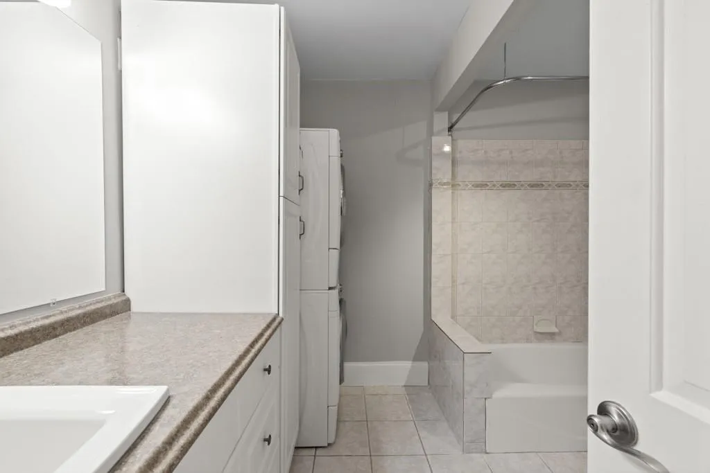 Bathroom featuring tiled shower / bath, vanity, and tile patterned floors
