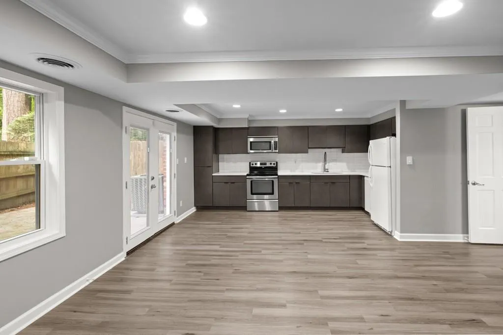 Kitchen featuring light hardwood / wood-style flooring, appliances with stainless steel finishes, tasteful backsplash, ornamental molding, and sink